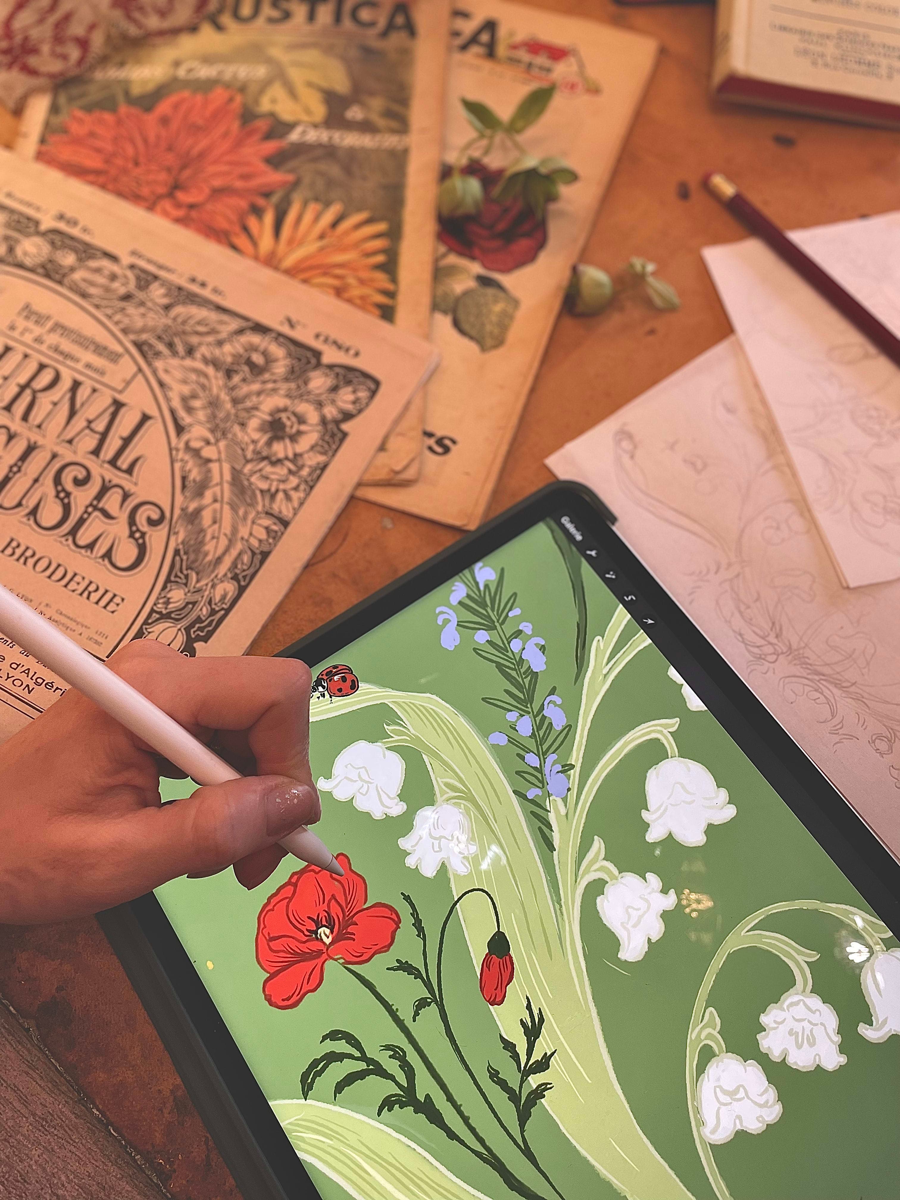 Illustrator's hand holding a stylus over a digital tablet for line drawing