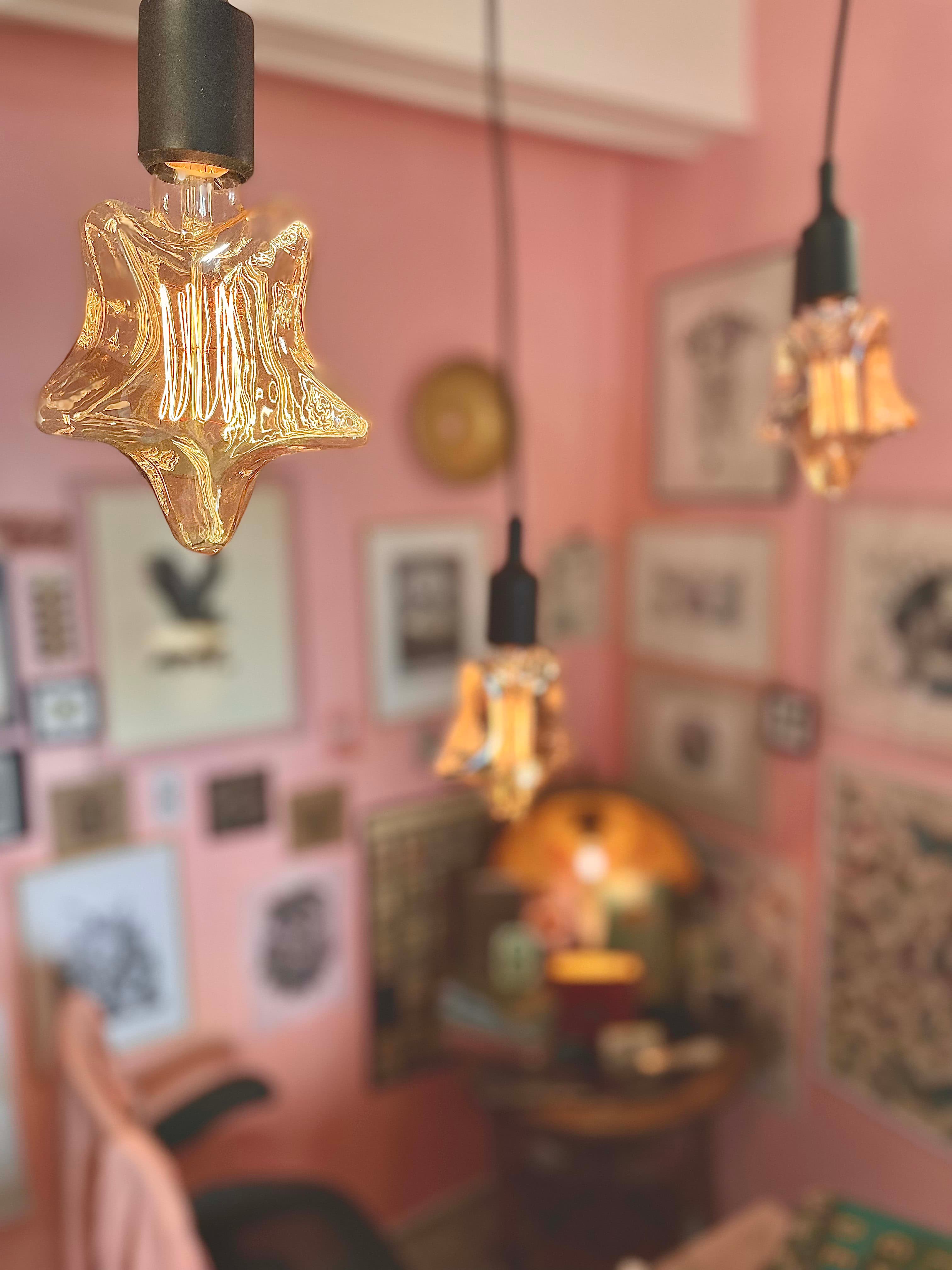 Studio interior with star-shaped chandelier suspended in a dusty pink atmosphere
