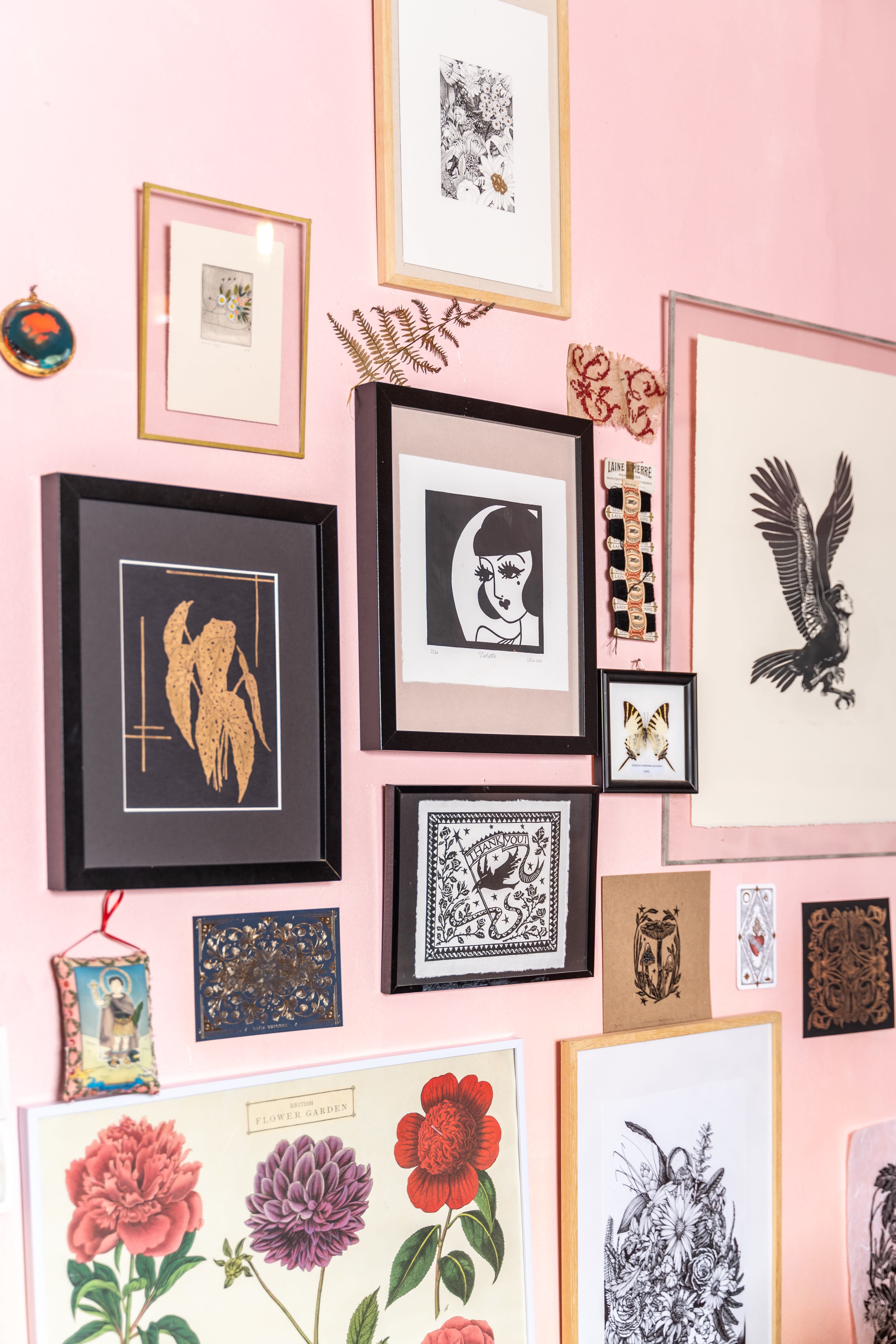 Dusty pink studio wall covered with framed drawings and illustrations in quiet luxury aesthetic