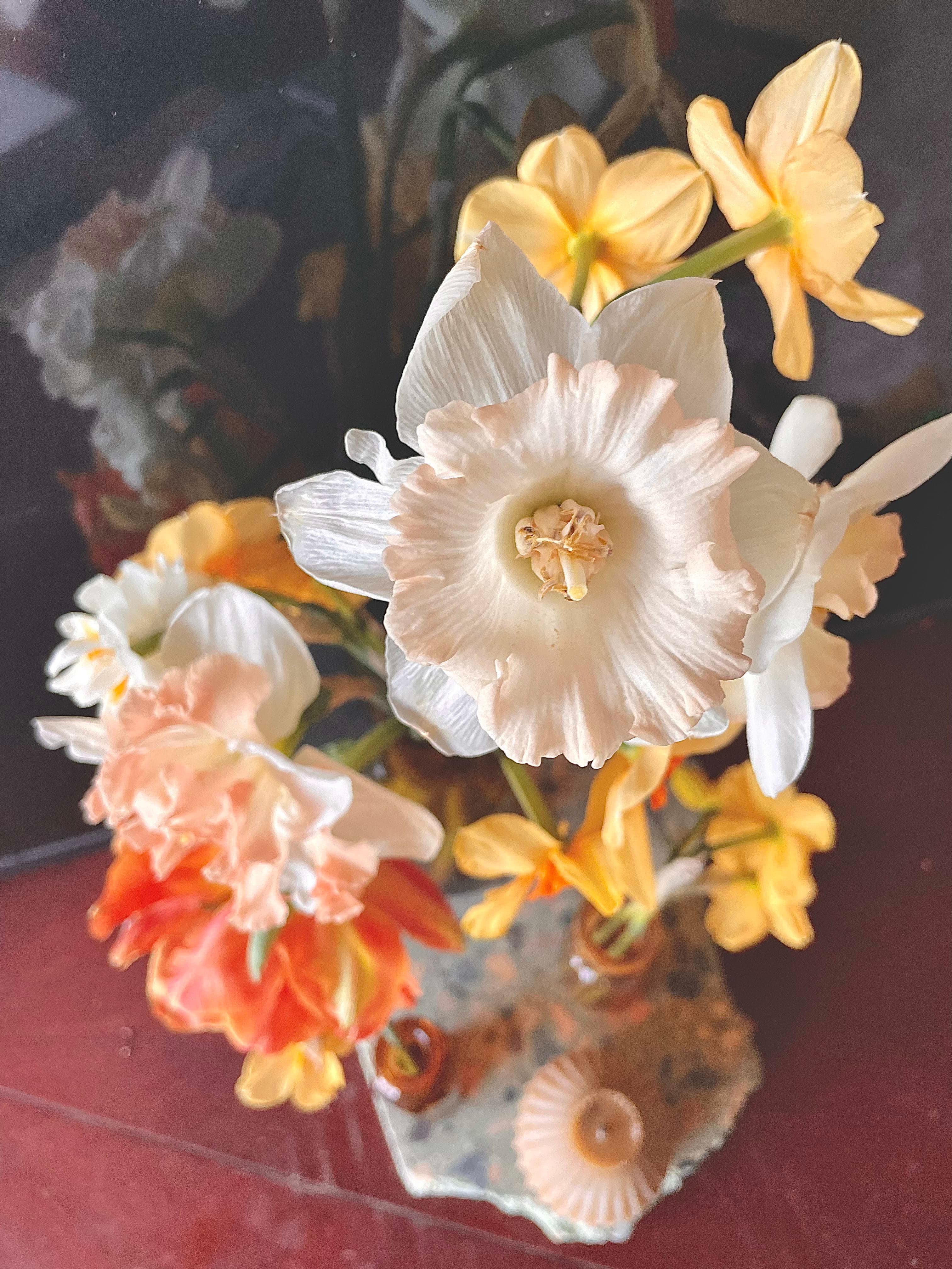 Floral composition of narcissi in a vase on wood in decorative botanical style
