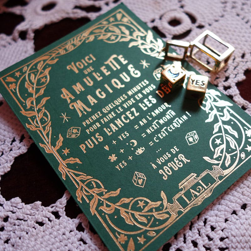 LA2L amulette card. Hot stamped gold foil on a forest green paper