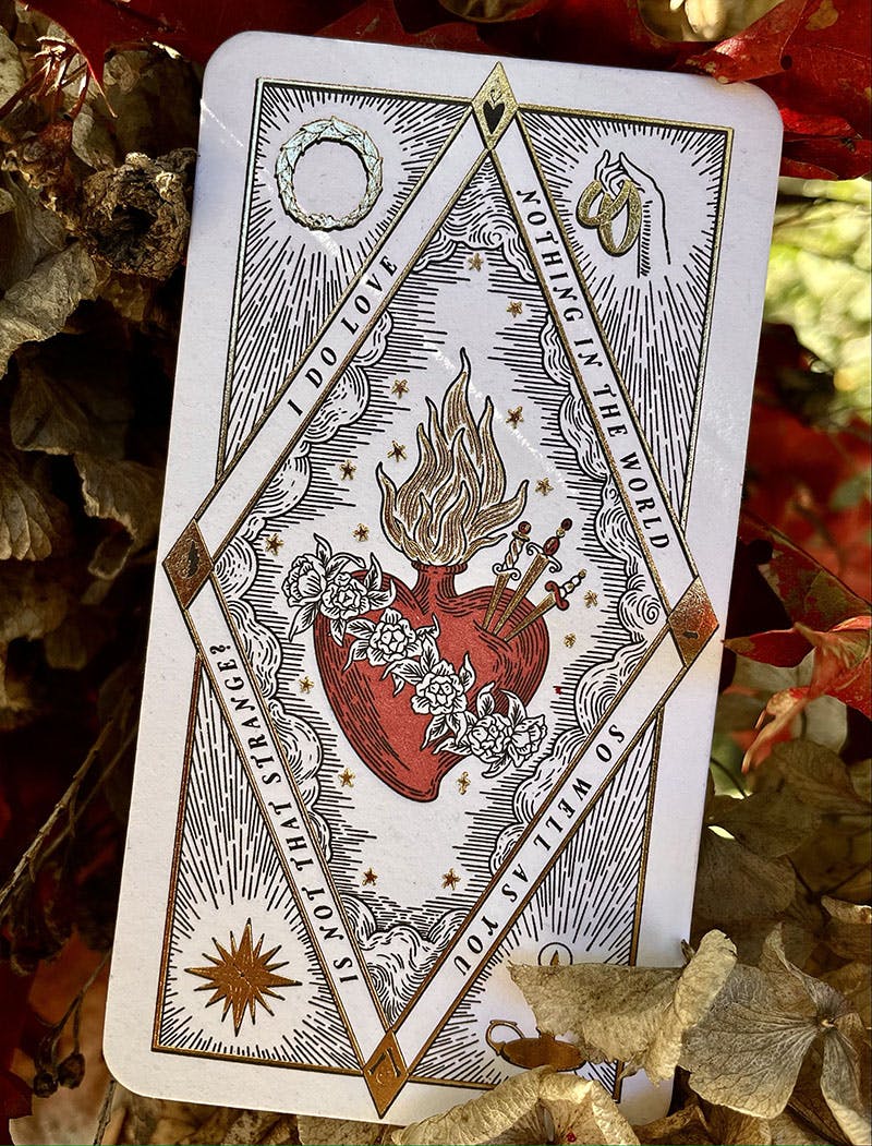 a card with a heart on it surrounded by leaves