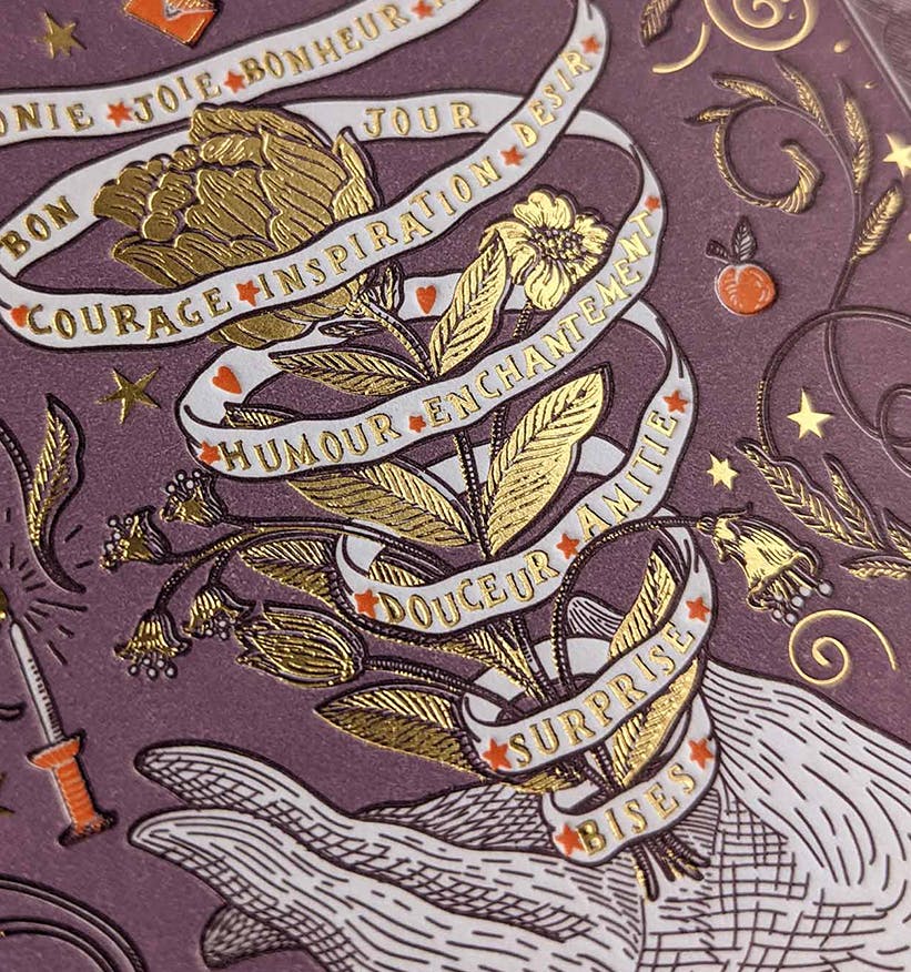 Le souhait letterpressed card closeup. gold, purple and orange